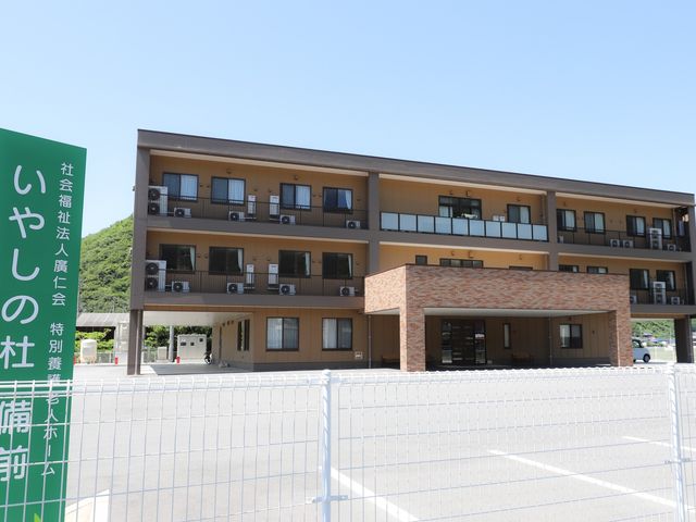 前方の看板と建物 外観 広々とした駐車スペースを備えた建物です。正面にシンプルで落ち着いた外観が広がっています。