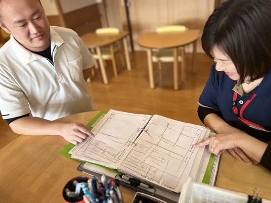 書類を確認する職員と利用者  