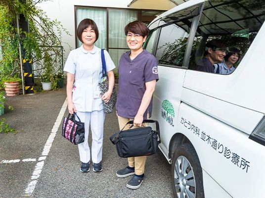 送迎車前の職員2人と外観  