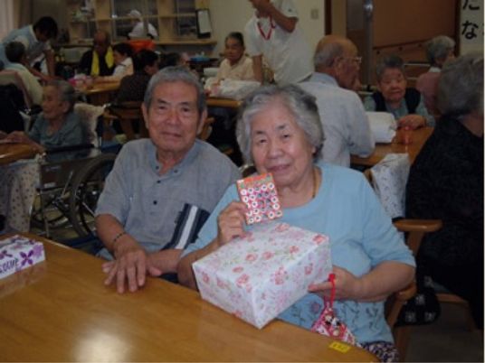 笑顔のご夫婦と活気のある食堂