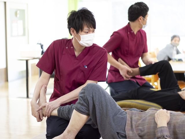 スタッフの丁寧なケア 機能訓練室 スタッフが一人一人の動きに合わせて手厚く支援している安心の空間です。利用者と寄り添う心地よい場で、機能回復に取り組めます。