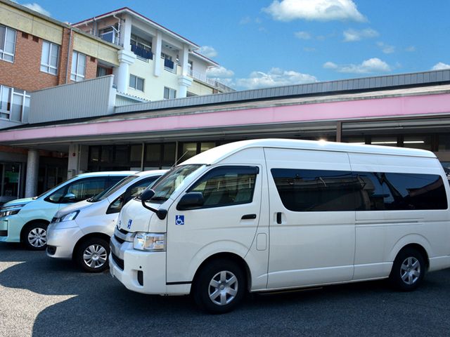 送迎車が並ぶエントランス エントランス 複数の送迎車が停まっていますので、通勤の際も安心です。施設利用者の移動もスムーズに。