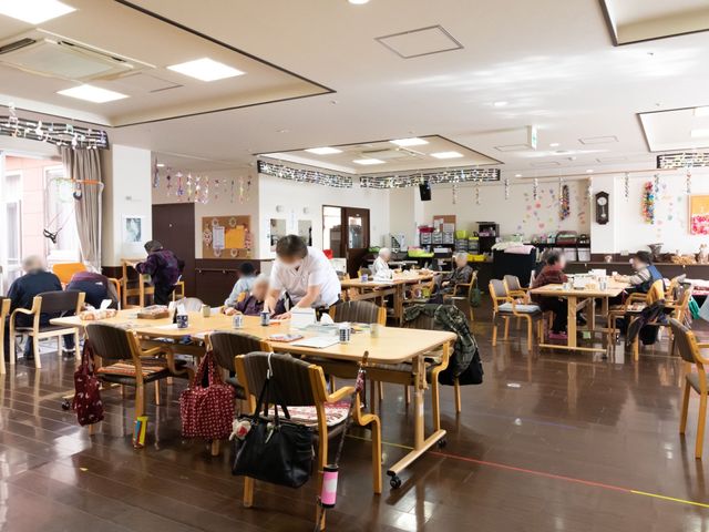 活気ある食堂 デイサービスルーム 広々とした明るい食堂で、利用者の皆さまがお食事や交流を楽しまれています。快適な環境で、毎日の業務に従事できる場所です。