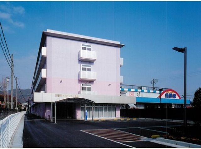 ピンクの壁の建物外観 外観 この建物は鮮やかなピンク色の外壁が特徴的で、明るい雰囲気の環境を提供しています。訪れる方々を温かく迎えるデザインになっており、快適な勤務が期待できそうです。