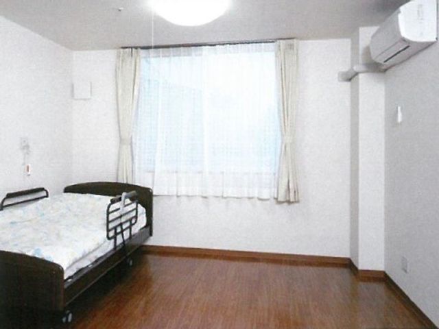 明るい個室居室 居室 広々とした居室には、必要な備え付けが整っており、明るい日差しが差し込む窓が心地よい空間を演出しています。