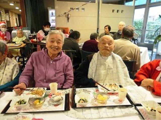 笑顔の高齢者と食事風景 食事 笑顔で食事を楽しむ高齢者がいる温かな食堂です。ここでは多くの方が日々の食事を通じて交流を深めています。