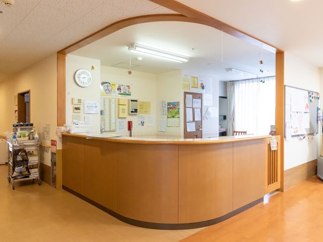 受付カウンターのあるロビー 職員室 開放感のある受付スペースです。スタッフが笑顔で対応しており、安心してお仕事をスタートできそうです。