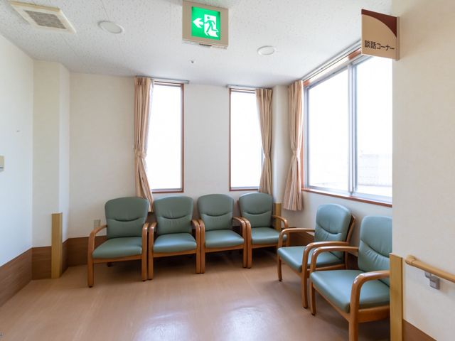 待合室の綺麗な椅子 談話コーナー やわらかな光が差し込む、ゆったりとした待合室です。木製のアームチェアが清潔感のあふれる空間を演出しています。