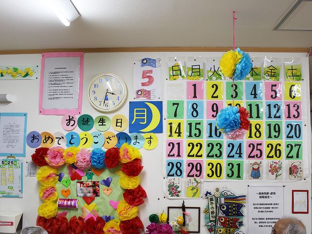 掲示物が並ぶ廊下 掲示物   カラフルな飾り付けで、利用者の誕生日を祝う温かい雰囲気が感じられるスペースです。