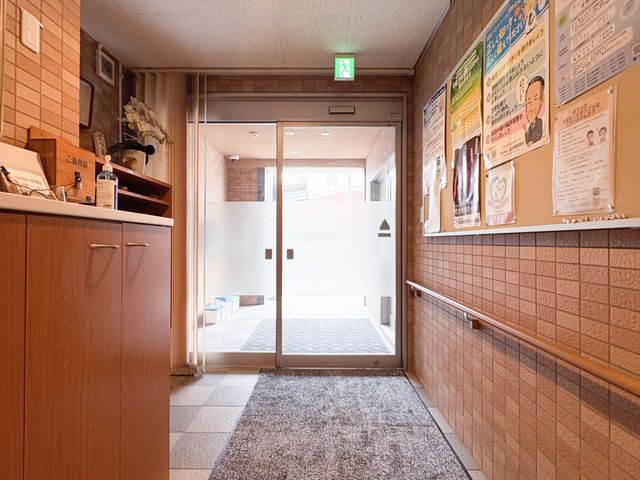 明るい出入口の廊下 廊下   明るい出入口へ続く、細長い廊下です。壁の掲示物が見やすく、案内や情報共有がしやすそうです。