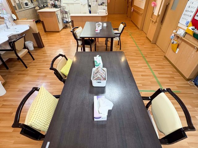 食堂テーブルと通路 食堂   木目調の床と落ち着いた色合いのテーブルが並ぶ食堂です。通路も広く、移動しやすい空間に見えます。