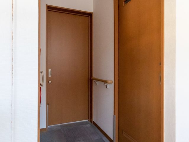 廊下とドアの写り込み 居室 広々とした廊下には手すりが設置されており、移動の際のサポートが心配りされています。明るく清潔感のある設計です。
