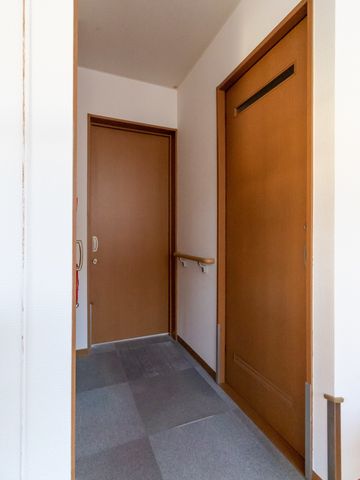 廊下とドアの写り込み 居室 広々とした廊下には手すりが設置されており、移動の際のサポートが心配りされています。明るく清潔感のある設計です。