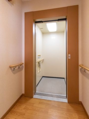 ゆったりとしたエレベーター入口 エレベーター 手すり付きで安全に配慮されたエレベーター入口です。床には滑りにくい素材を使用しており、ご高齢の方でも安心してご利用いただけます。