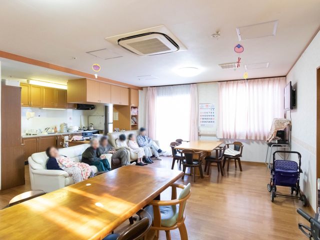 居心地の良いリビング空間 共有スペース ゆったりとした座席でくつろぎながら、共に時間を過ごす方々のあたたかな交流の場です。家庭的な雰囲気のキッチンも備わり、日常生活に安らぎを提供しています。