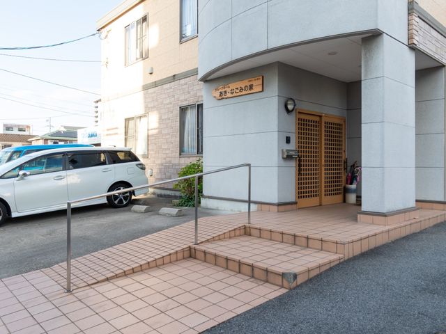 施設の明るいエントランス 玄関 入口には手すりが備えられ、バリアフリーの構造を採用しており、ご利用者の安全な移動を支援しています。