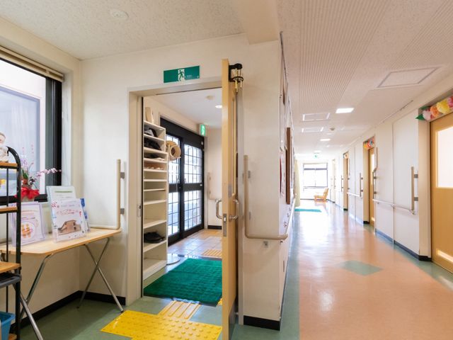 廊下の手すり付き通路 玄関ホール 明るく清潔感のある通路が、皆様をしっかりと支えます。手すりが設置され、安全に配慮した環境での快適な就業が期待できます。
