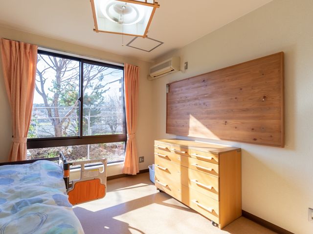 日当たりの良い居室 居室 窓から自然光が差し込む、落ち着いた雰囲気の居室です。ベッドや家具が配置され、快適な個人空間をお約束します。