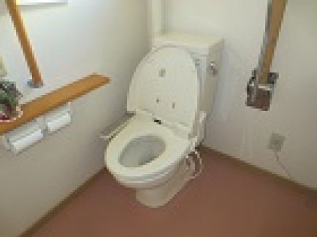手すり付きの白いトイレ トイレ 壁に手すりが設置されており、安全に配慮された広いスペースのトイレです。