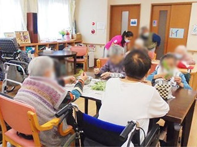 皆で作業する空間 多目的室 利用者が集まり、和やかな雰囲気で作業を楽しむ様子です。多目的に利用可能な広々とした空間です。