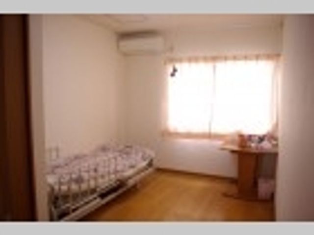 採光豊かな居室 居室 ゆったりとしたベッドと光が差し込む窓が特徴の居室です。窓辺には個人の趣味を楽しむための机と椅子も備わっており、快適な時間を過ごせる空間になっています。
