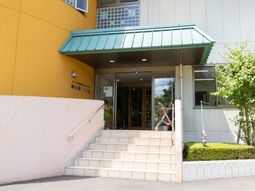 エントランス付きの黄色い建物