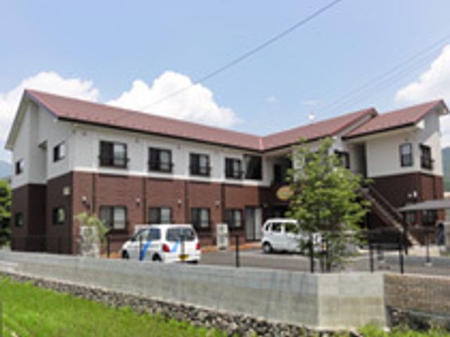 明るい日差しの中の施設外観 外観 緑豊かな環境にたたずむ施設でそよ風とともに、心地よい日々を過ごす仕事をしませんか。