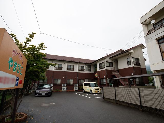 施設の外観と駐車場 外観 落ち着いた色合いの建物が目を引く、駐車スペースも確保された環境です。訪れる方々を温かく迎えます。