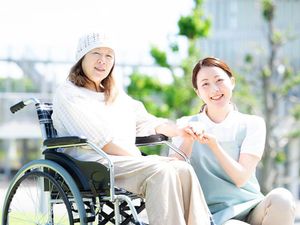 車椅子の利用者と笑顔のスタッフ
