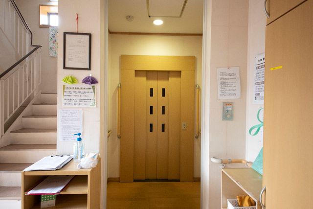 エレベーター正面の入口 エレベーター 手すりが付いたエレベーターの入口は、利用者の安全を考えた設計です。階段と並ぶこの場所では、日々の移動がより快適になります。
