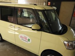 黄色い送迎車とロゴ