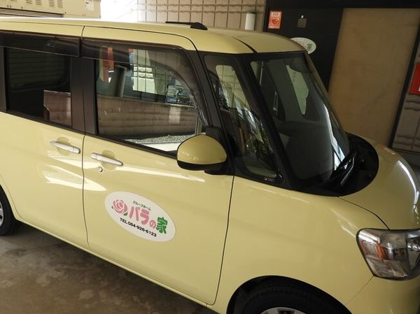 黄色い送迎車とロゴ