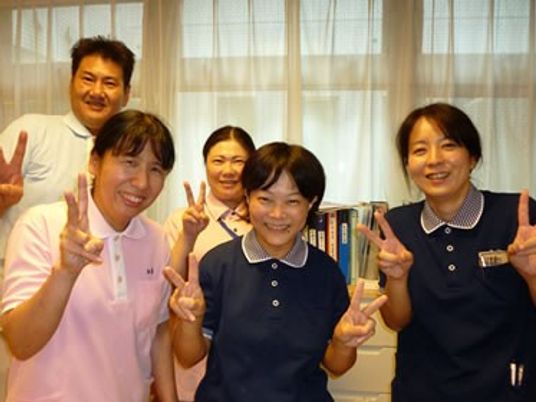 笑顔の職員が並ぶ部屋  