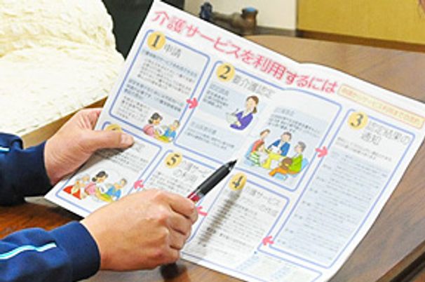 利用案内を手にする姿