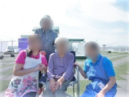 屋外で笑顔の高齢者とスタッフ