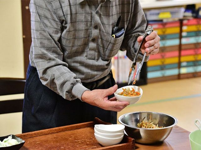 食事準備中の様子 食堂 食事の準備を楽しむ光景。スタッフと協力し、和やかな雰囲気の中で配膳作業を行っています。