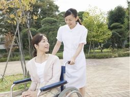 笑顔で車椅子を押すスタッフ