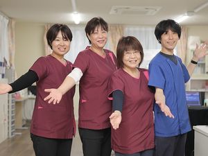 笑顔のスタッフ4人が並ぶ休憩室  