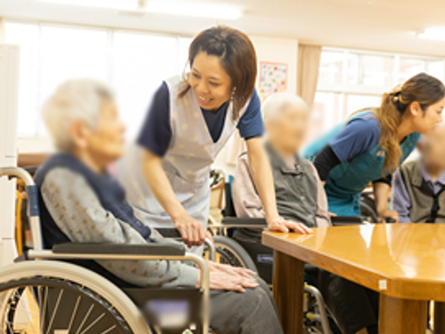 和やかな雰囲気のラウンジ ラウンジ 自然光が差し込む広々とした空間で、入居者とスタッフが和やかにコミュニケーションを取っています。