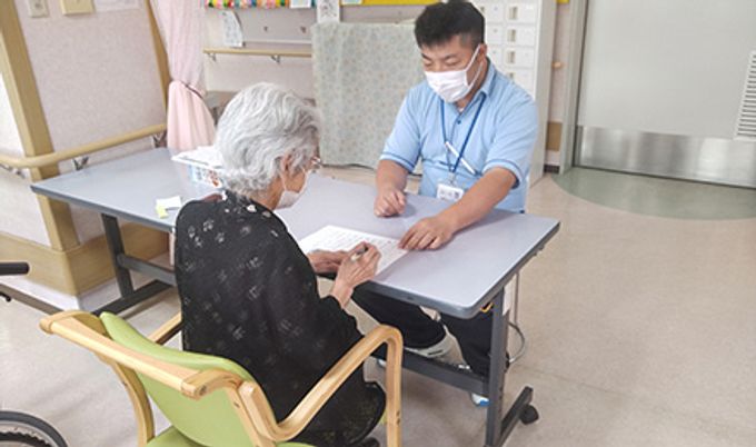 机で会話する様子の居室