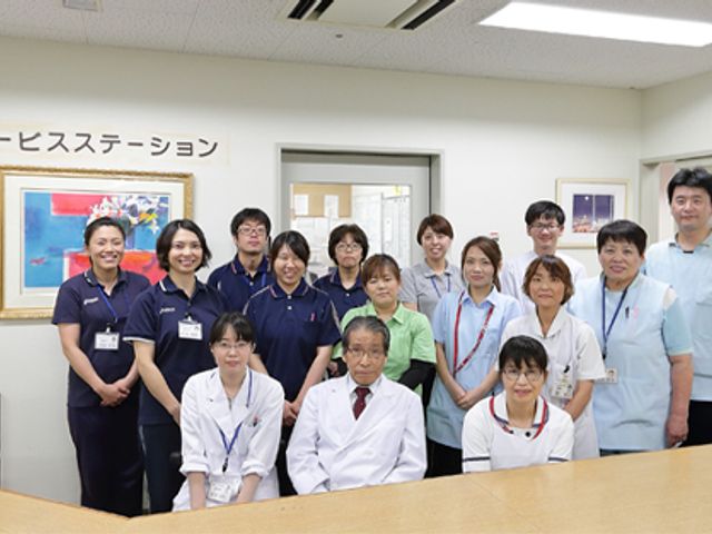 笑顔のスタッフが集う様子 スタッフイメージ 明るい雰囲気の中で和気あいあいとしたスタッフの集合です。安心して働ける環境が整っています。