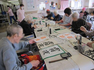 書道を楽しむ高齢者たちの居室