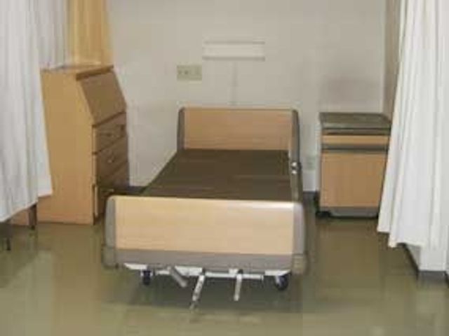 ベッドと家具がある部屋 居室 コンパクトに配置された家具とベッドが整った空間です。シンプルな居室で働きやすさが感じられます。
