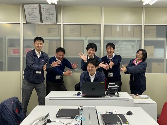 笑顔のスタッフたちが並ぶ休憩室  
