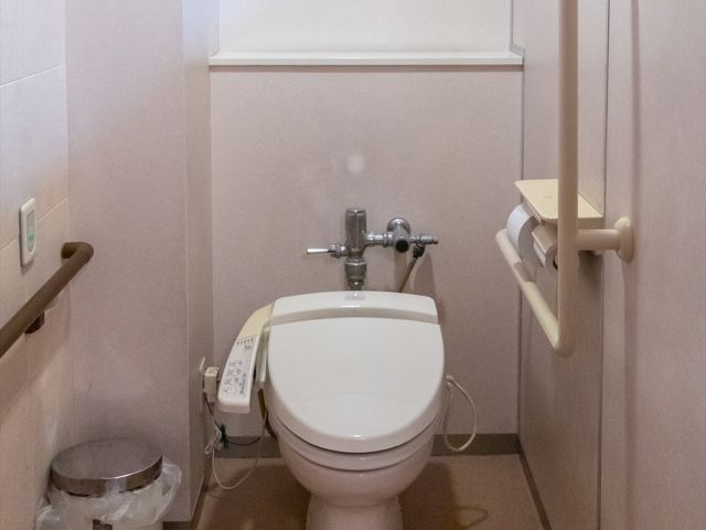 手すり付きトイレの設備 トイレ 安全なサポートを提供する手すりが設置されたトイレです。利用者の日々の快適な生活をサポートしています。