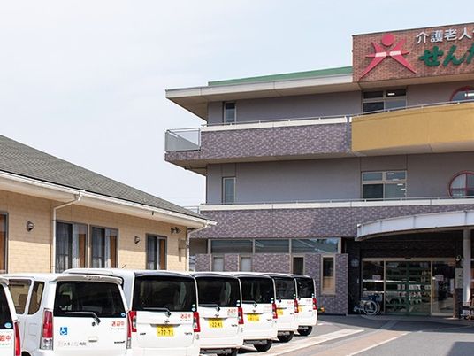 送迎車が並ぶ建物外観  
