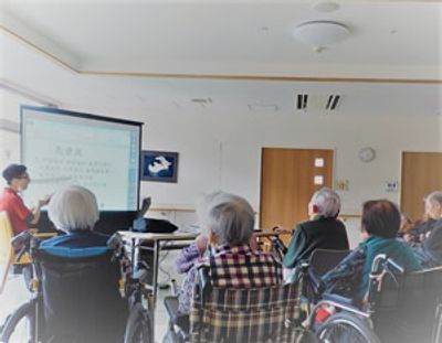 椅子に座る人々とスタッフ