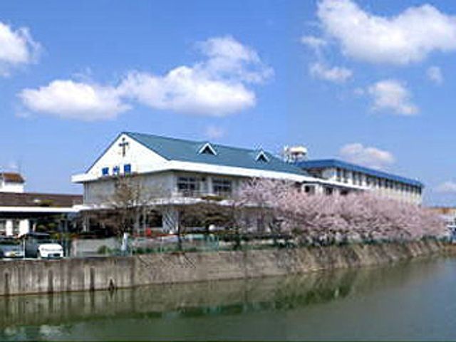 川沿いの建物外観 外観 施設の外観は川沿いに位置し、季節ごとに桜の花が美しく咲き誇ります。