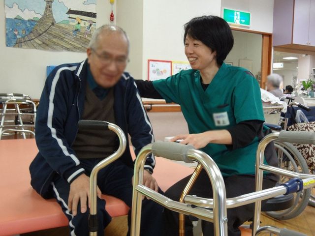 温かい交流の様子 機能訓練室 リハビリテーション中にスタッフが丁寧にサポートする心温まる光景が見られます。