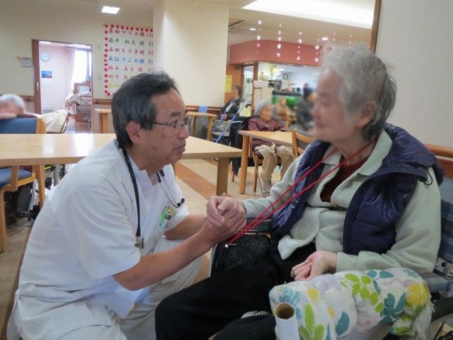 静かに話すスタッフと利用者 ラウンジ スタッフが利用者に寄り添い、穏やかに談笑できる落ち着いた空間。和やかなひとときを提供します。